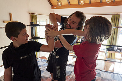 Trainer Fynn Freyhart zeigt den Kindern die richtigen Wrestling-Griffe.